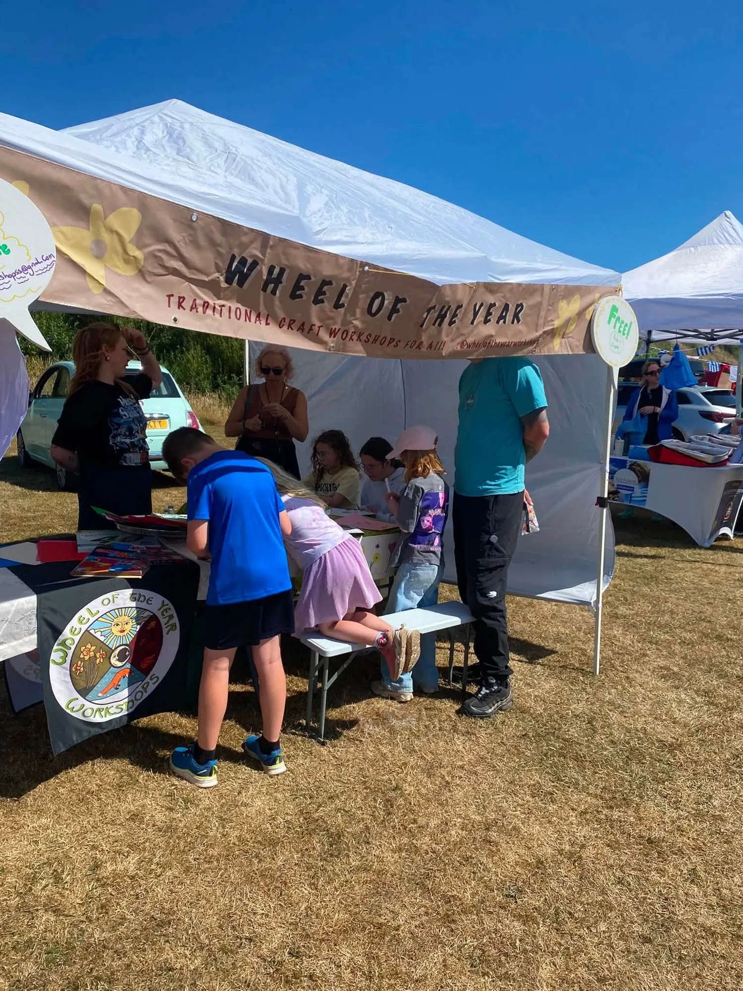 The Wheel of the Year stall at Arbroath Market, with children drawing at the table