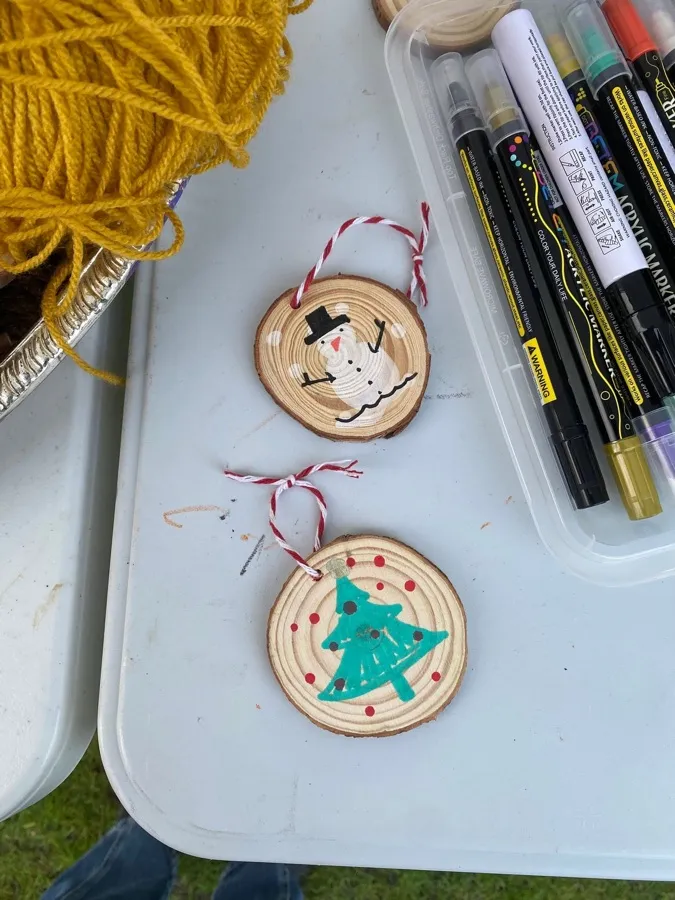 Two painted wooden slice decorations hung on red and white string